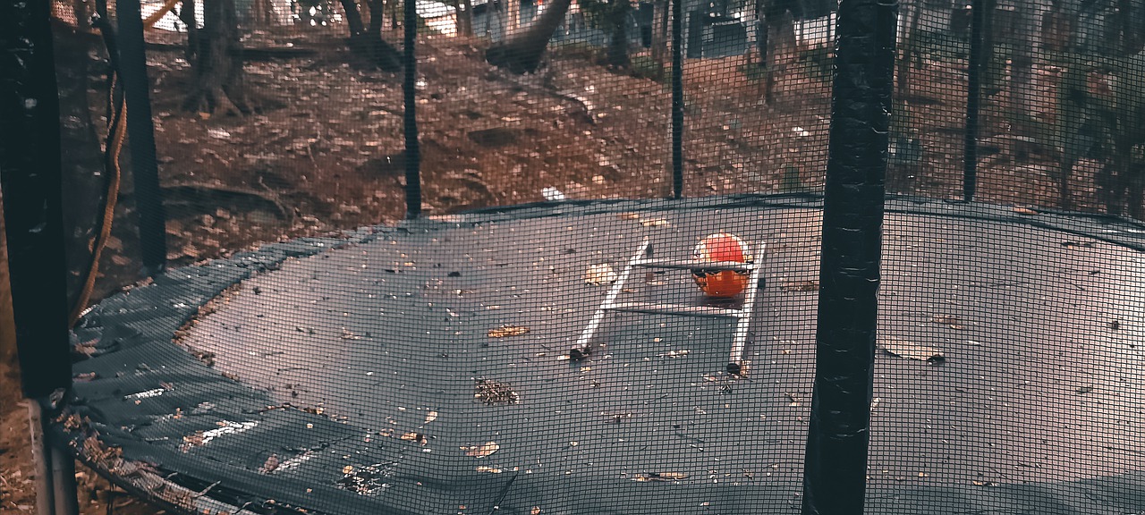 trampolin-mit-laub-und-leite-in-garten